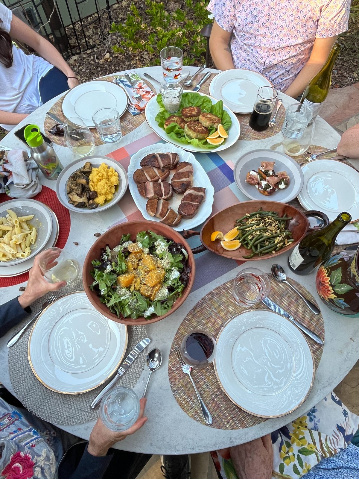 Backyard dinner spread with seared duck, salad, and sides