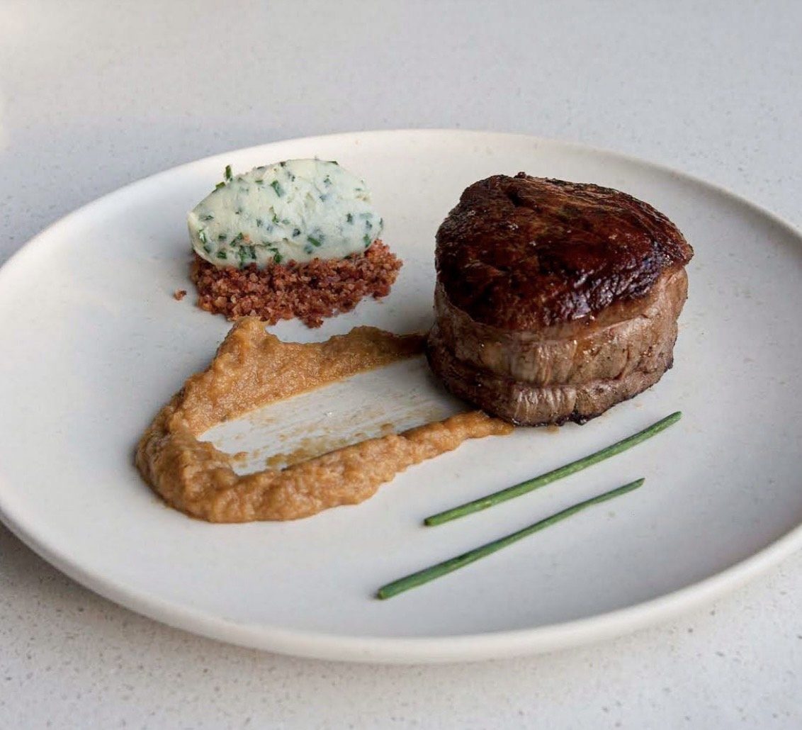 Plated filet mignon with herb butter and pan sauce
